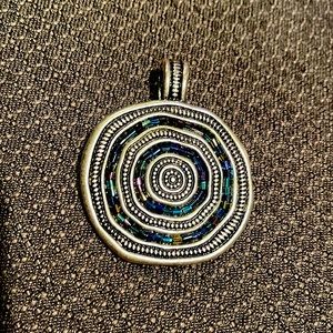 I used to wear this on a leather string or a piece of silk string.